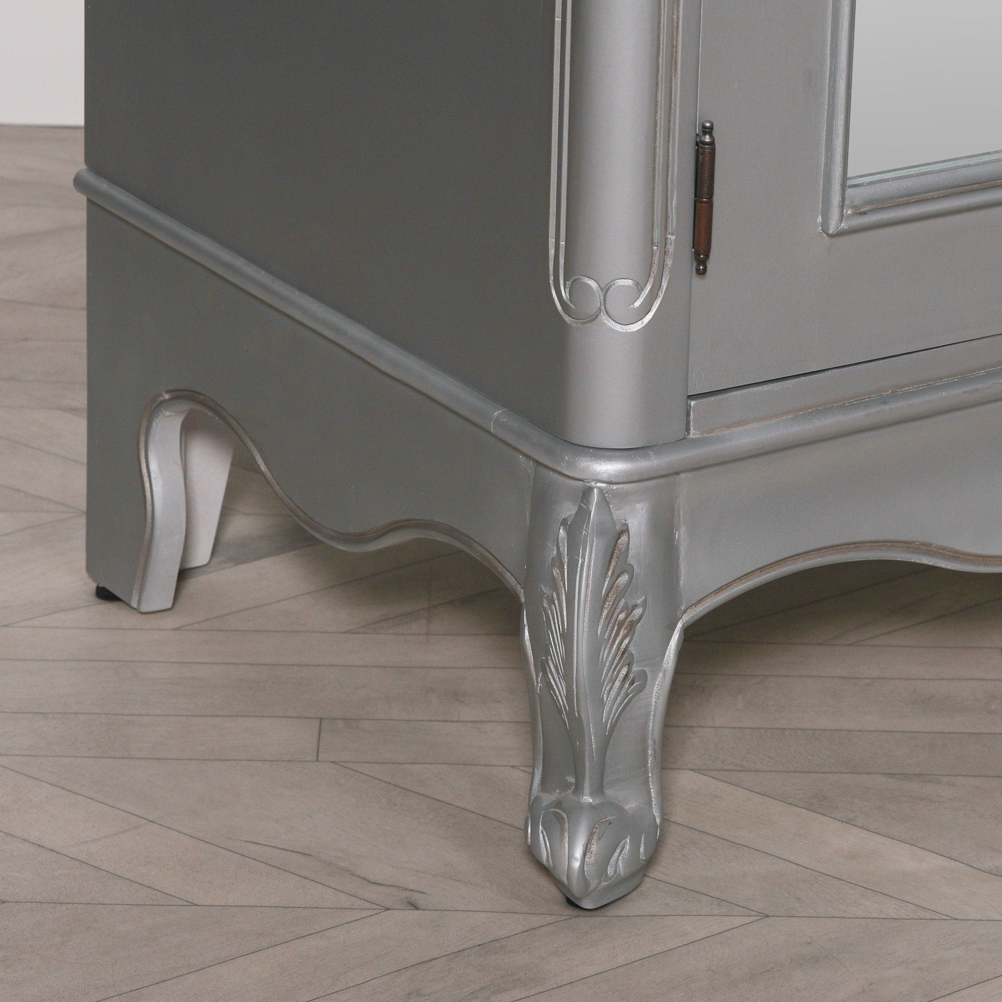 Close-up of the Vivienne Silver Carved Mirrored Double Door Armoire Wardrobe featuring intricately carved cabriole feet, decorative apron, silver painted finish and traditional French craftsmanship.