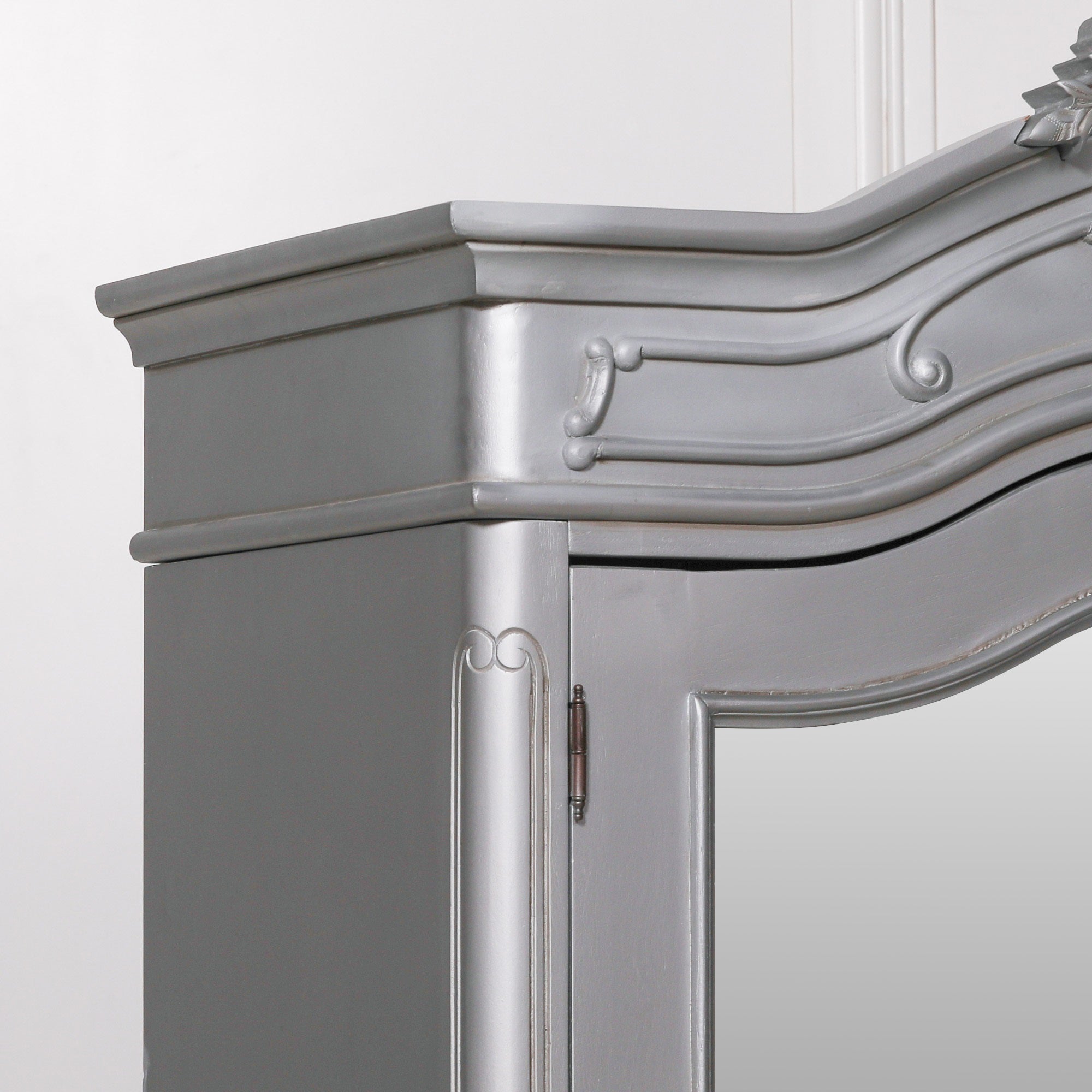 Close-up of the Vivienne Silver Carved Mirrored Double Door Armoire Wardrobe showcasing the sculpted cornice, decorative mouldings, silver painted finish, mirrored door frame and handcrafted French-inspired detailing.